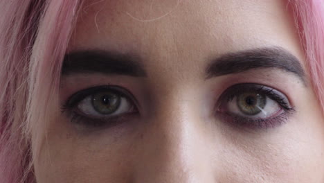 cerca de la mujer los ojos abiertos mirando a la cámara punk mujer cabello rosa