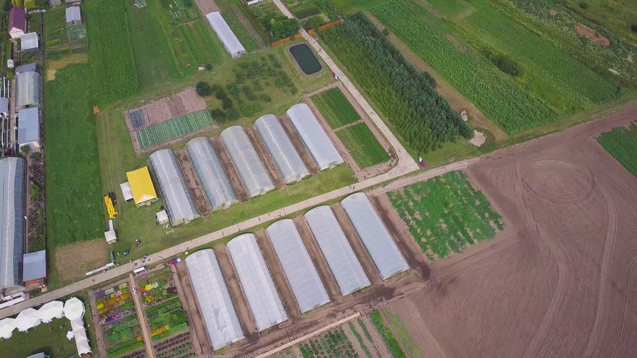 온실 과 야외 작물 이 있는 큰 농장 의 공중 사진