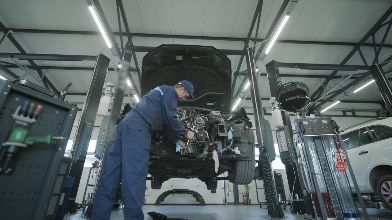 자동차 작업장에서 자동차 엔진을 수리하는 기계공