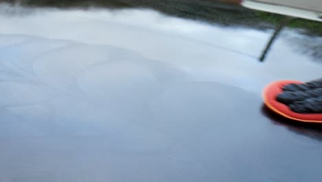 polishing a black car by hand - extreme close up