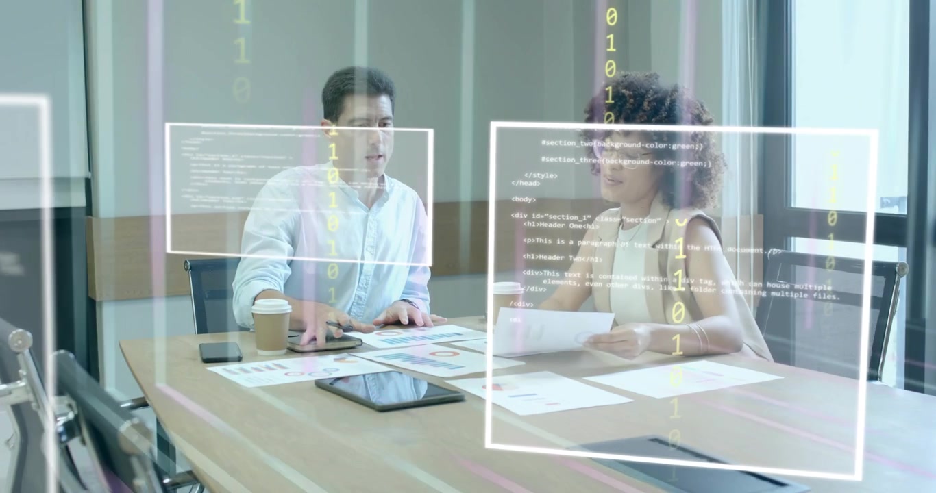 Donna che indica un grafico e uomo che prende appunti mentre un codice AR si attiva per l'analisi dei dati aziendali.