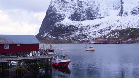 cinematic tracking shot of a boathouse and fishing boats in reine, lofoten