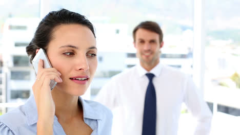 una mujer de negocios hablando en su teléfono inteligente.
