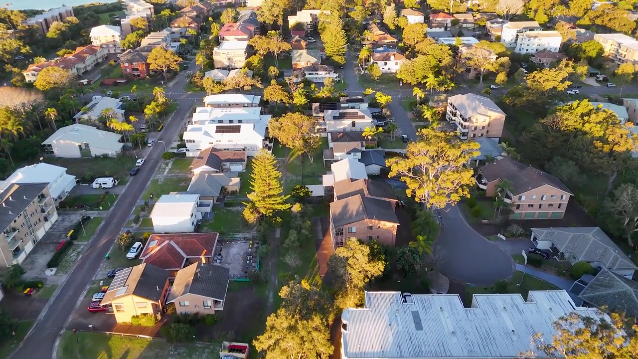 Droneoptagelse fra høj vinkel over hustage og gader i beboelsesområder i Nelson Bay, New South Wales
