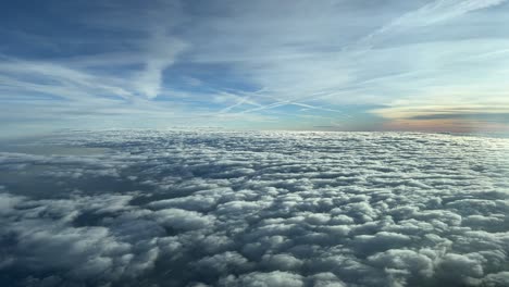 Stunning-pilot-poin-of-view-form-a-jet-cockpit-overflying-a-sky-plenty-of-clouds-during-the-descent-in-a-cold-winter-sunset