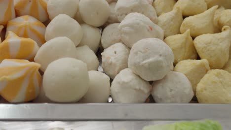 bolas de pescado y varios ingredientes bandejas para shabu-shabu comida asiática, de cerca