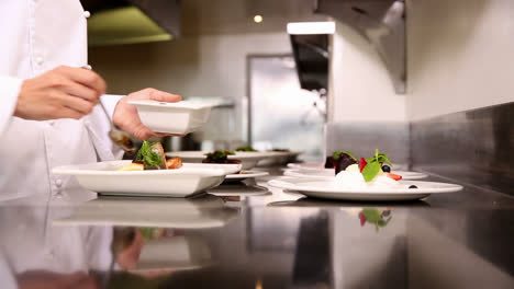 chef pouring sauce over dishes