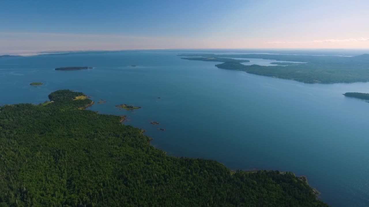 동부 캐나다 해안의 큰 파란 물체, 울창한 녹색 숲과 섬으로 둘러싸여 있습니다.