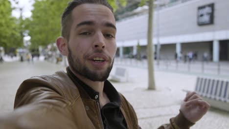 handsome young man recording video outdoor.