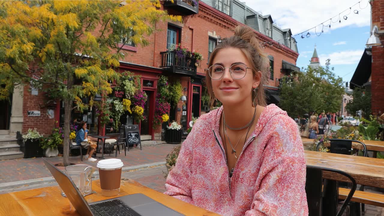 Relaxing at a Cozy Outdoor Café Surrounded by Vibrant Flowers and Charming Architecture, Enjoying a Warm Beverage and Working on a Laptop in the Comfortable Space