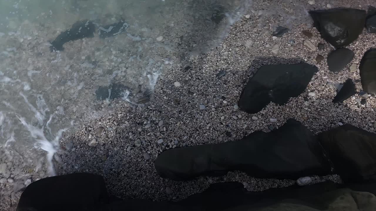 해변에 있는 검은 돌들이 바다의 파도에서 조각된, 지중해의 야생적인 아름다움의 해안선, 손상되지 않은 해안