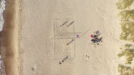 aerial: volleyball match with long shadows of players on a sand