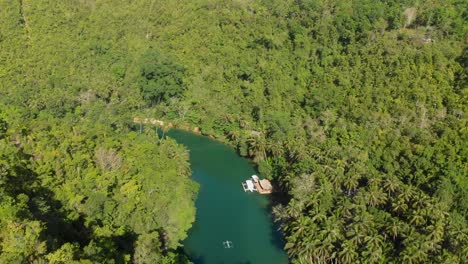 Un-Dron-Panorámico-Aéreo-De-4.000-Disparos-Desde-Un-Río-En-Asia-En-Medio-De-La-Jungla-Revela-Lentamente-Un-Pequeño-Bote-Local-En-El-Río-Durante-La-Hora-Dorada