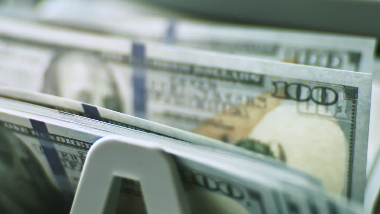 billetes de cien dólares en un dispensador