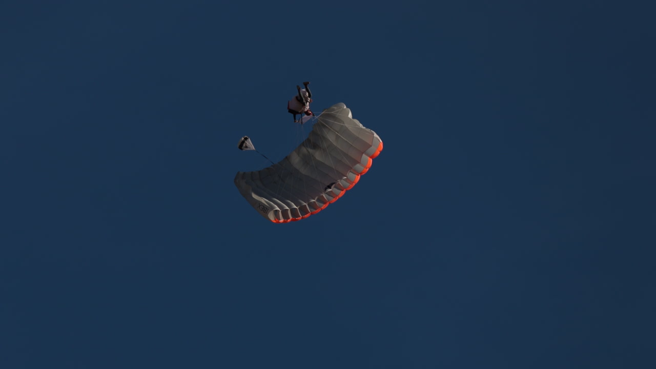 Wingsuit BASE jumper flying over Verbier surrounded by alpine mountains with snow-covered peaks. High-speed flight, dramatic scenery, and cinematic extreme sports action in the Swiss Alps.