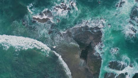 rough sea waves hitting rocks slow motion capture an aerial view