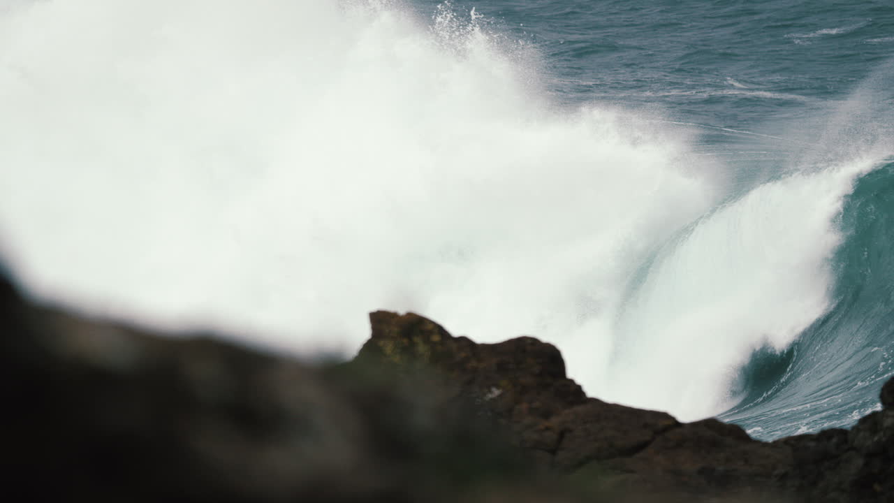 disparo bloqueado de gran ola rompiendo en rocas en cámara lenta