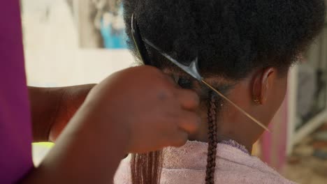 miembro del personal de la peluquería comienza a ajustar extensiones a la cabeza femenina