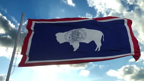 wyoming flag on a flagpole waving in the wind, blue sky background