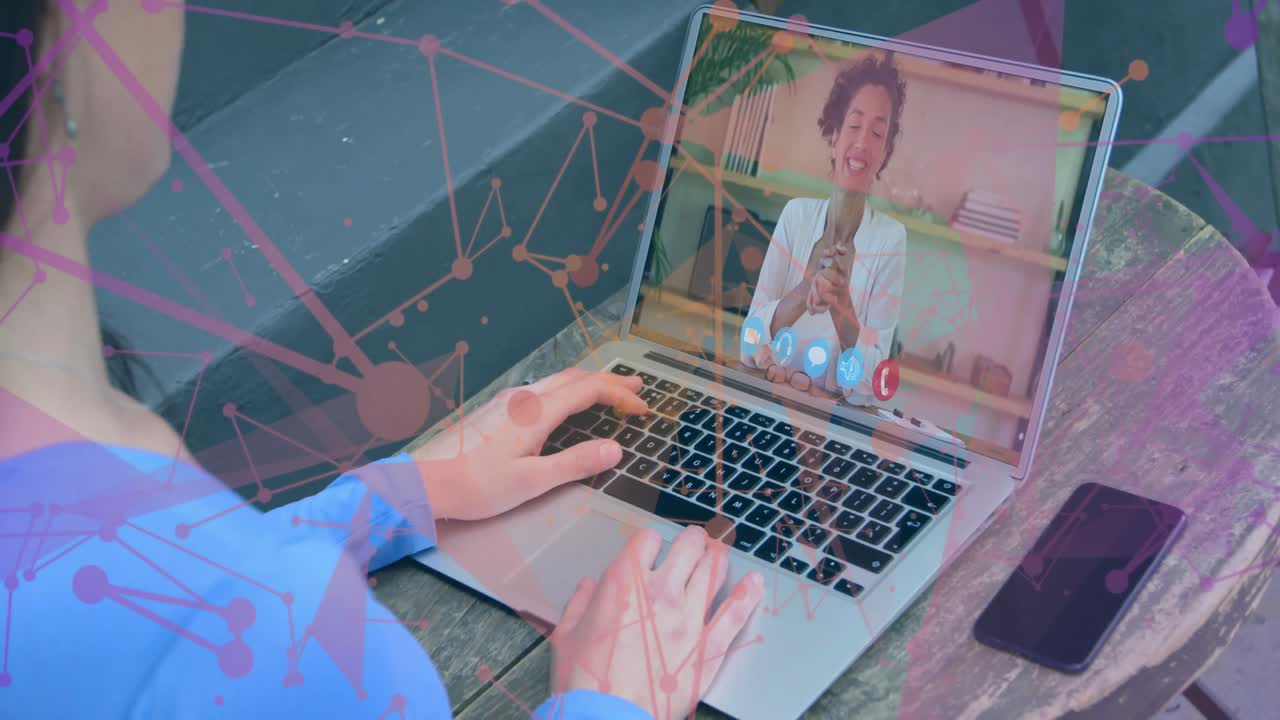 Mand taster på laptop udendørs under et fjernmøde, der viser telefon- og netværksgrafik