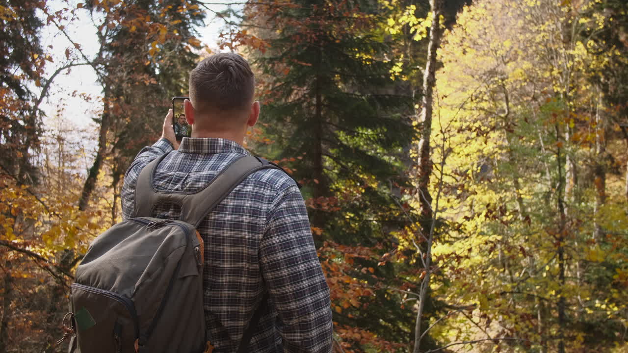 hombre tomando una foto en un bosque de otoño