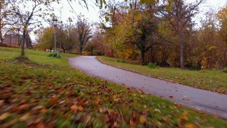 a-drone-flies-low-over-the-grass-in-the-park-and-passes-under-a-signboard