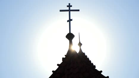 cross on the church tower in the rays of sunlight