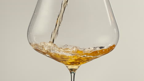 orange or white wine bottle and glass against a sunset in a peaceful vineyard, pouring of ecological natural wine.