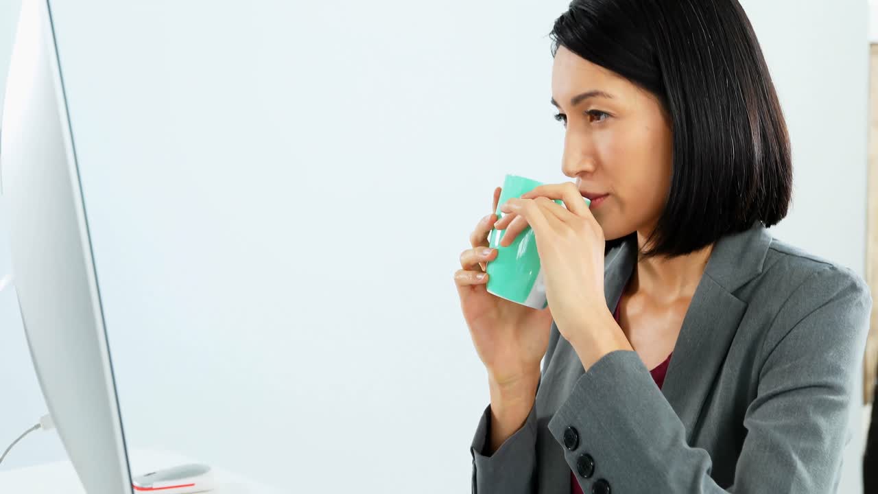 4k 데스크에서 일하는 동안 커피를 마시는 사업가