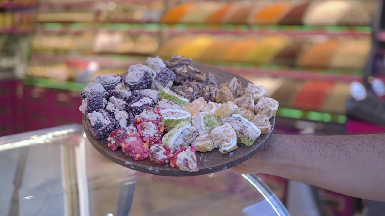 Mano che tiene un vassoio di delizie turche assortite