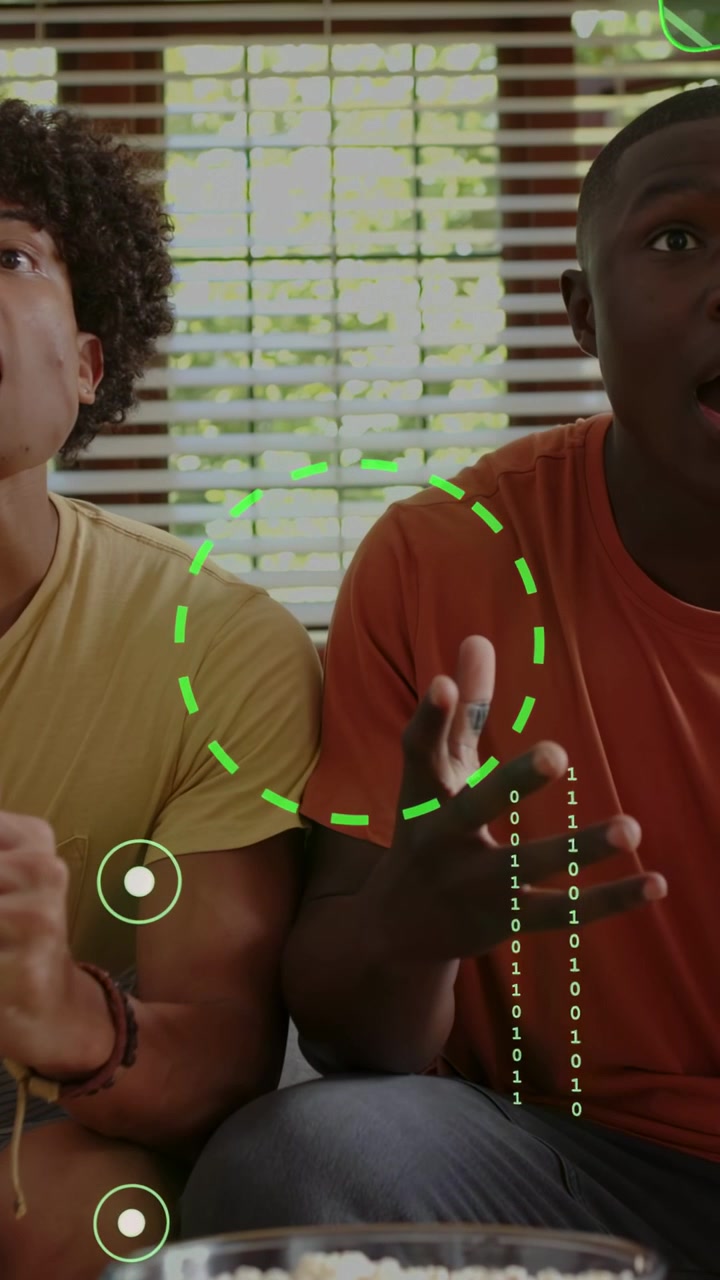 Vertical video: Green HUD appearing, two men leaning and gesturing on couch, showing ENCRYPT AES256