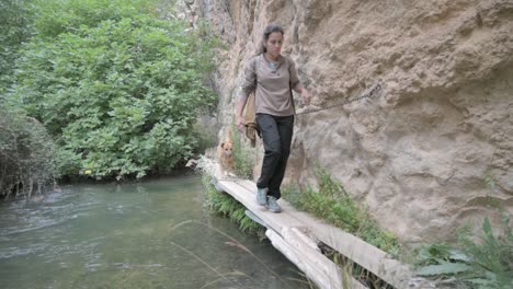 woman hiking with dog in canyon