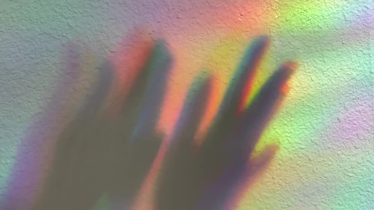 박수치는 손. 무지개 배경의 그림자