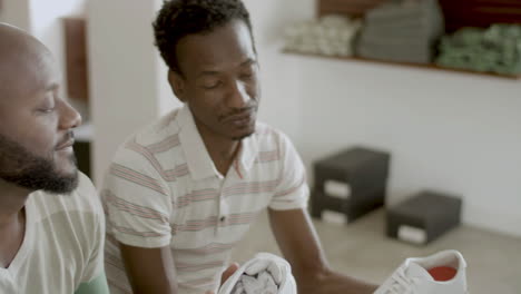 Closeup-of-handsome-black-male-couple-choosing-new-shoes-in-shop