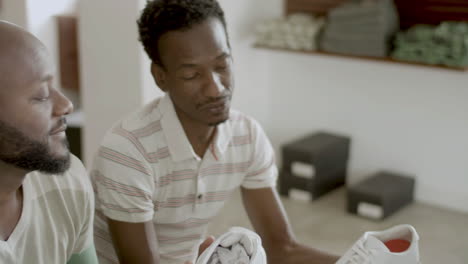 closeup of handsome black male couple choosing new shoes in shop
