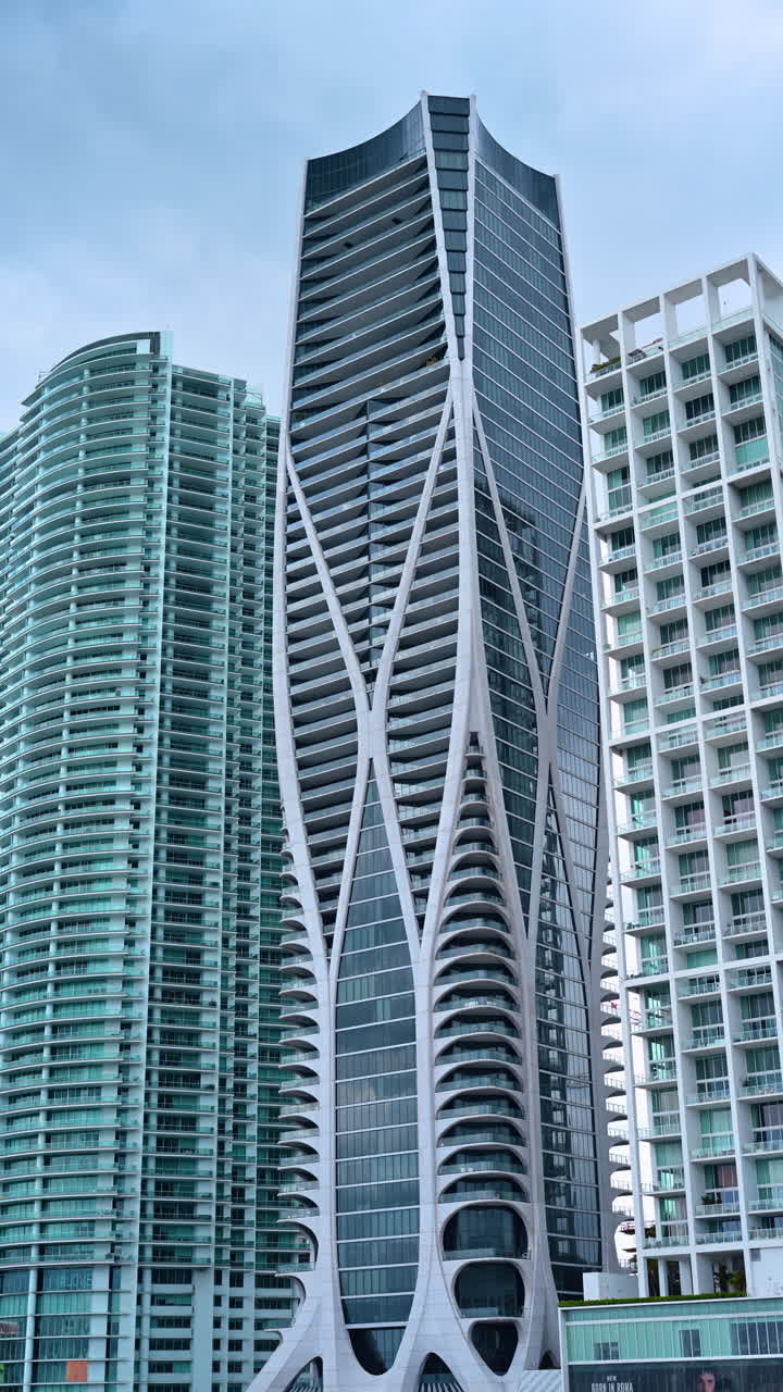 Grattacielo One Thousand Museum con un'architettura unica a esoscheletro bianco. Dettaglio del design moderno e sinuoso dell'edificio One Thousand Museum accanto a torri di vetro a Miami.