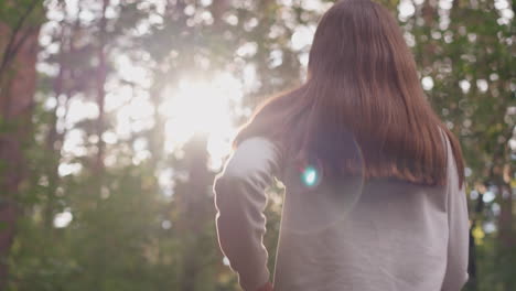 woman with long loose hair jogs in morning. young lady performs physical exercises to improve well-being relieving stress on warm summer day in forest