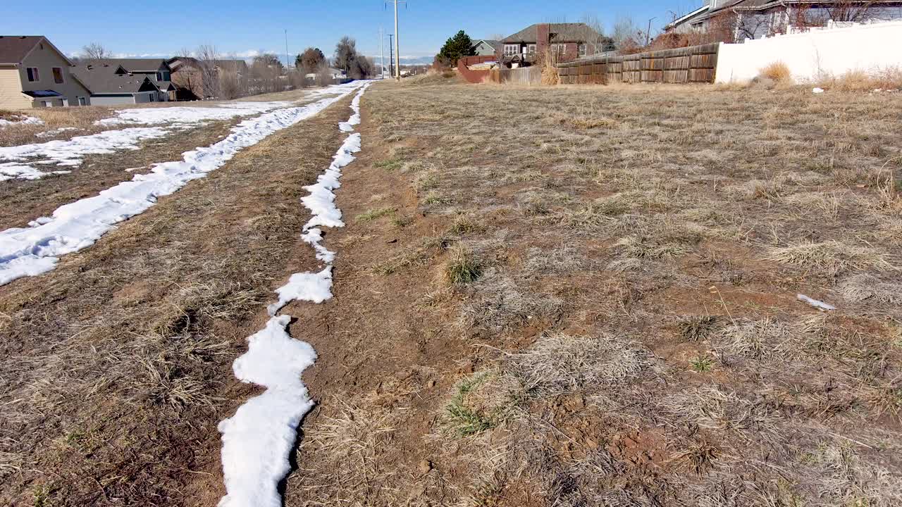 A utility access road in a neighborhood with high power lines.