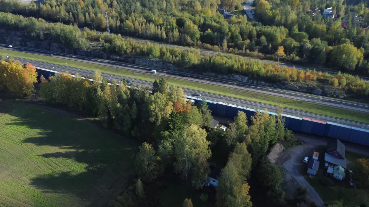 Aerial rotates over divided highway in autumn, northern boreal forest
