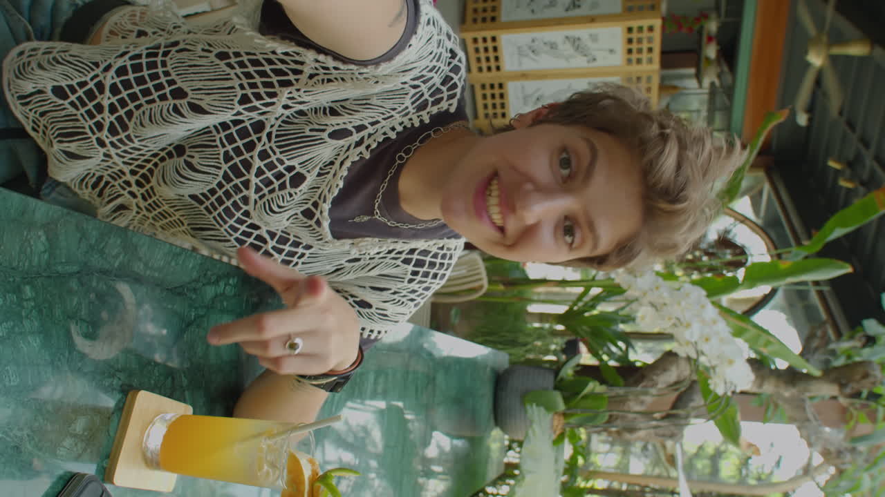 Woman Having Drink and Chatting on Camera in Outdoor Cafe