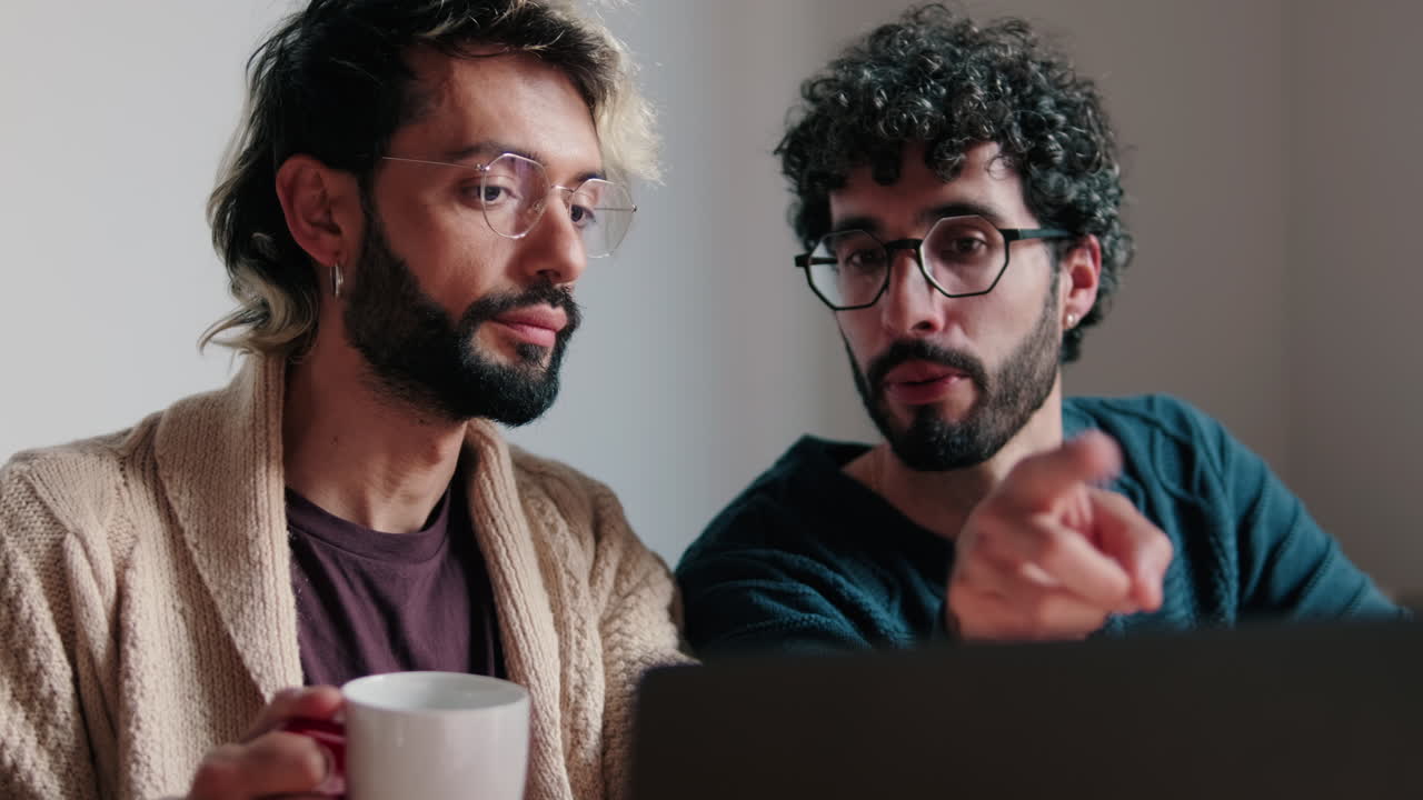 Gay Couple Working From Home on Laptop