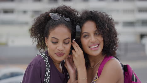 portrait beautiful hispanic twin sisters using headphones dancing together enjoying listening to music stylish female siblings having fun slow motion