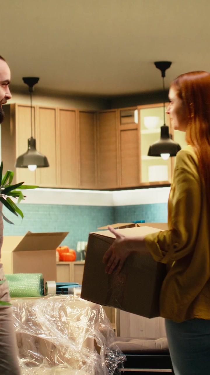 Vertical Video Young couple unboxing decorations in their new house,