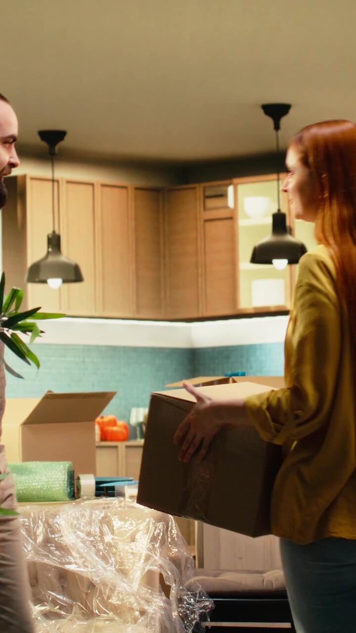 Vertical Video Young couple unboxing decorations in their new house,