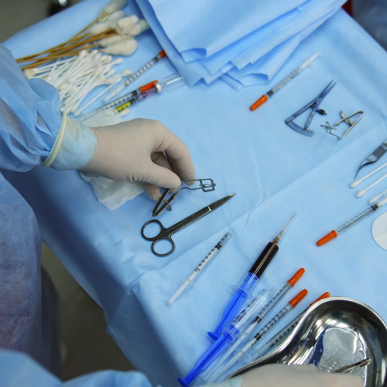 Medic chooses surgical instruments. Scalpel and scissors and syringes and needles and clamps. Instruments for the operation. Video from the top