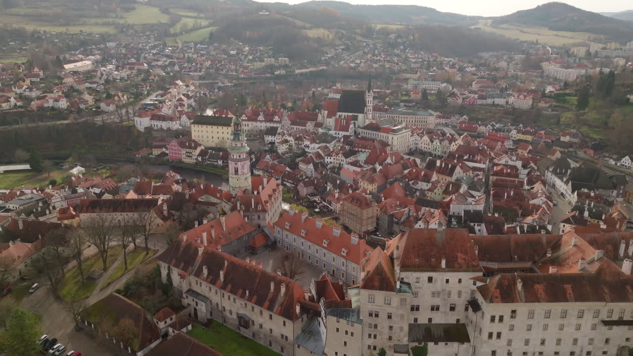 Høytliggende luftpanorama av Český Krumlov med tette, røde hustak og omkringliggende åser