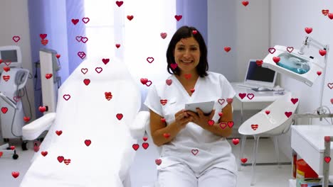 Aniamation-of-hearts-floating-over-happy-biracial-female-doctor-at-hospital