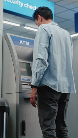 man using an atm machine in a security checkpoint