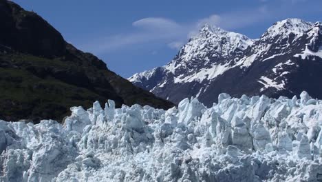 picos irregulares de hielo en la parte superior del glaciar margerie y las montañas cubiertas de nieve en el fondo