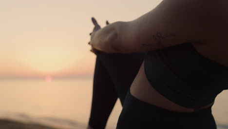 unknown girl standing one leg holding knee at sunset. woman stretching body.